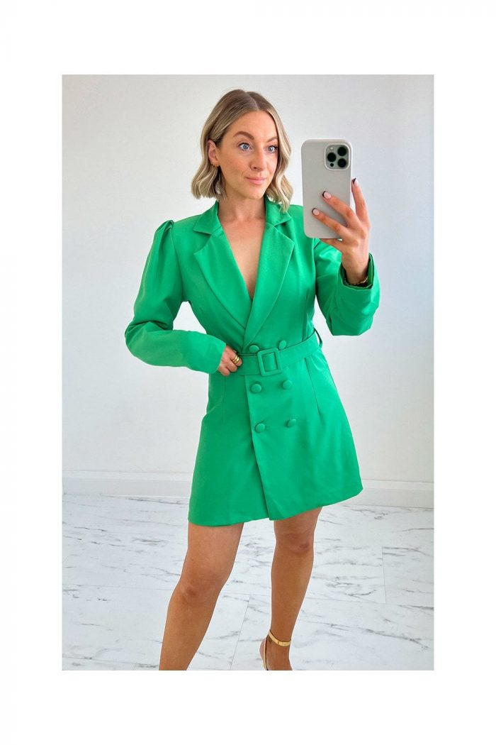 women wearing a bright green double breasted blazer dress buckled at the waist