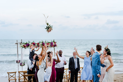 Image of a bride throwing her bouquet at an outdoor wedding