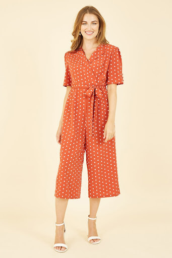 Image of a model wearing an orange wrap jumpsuit
